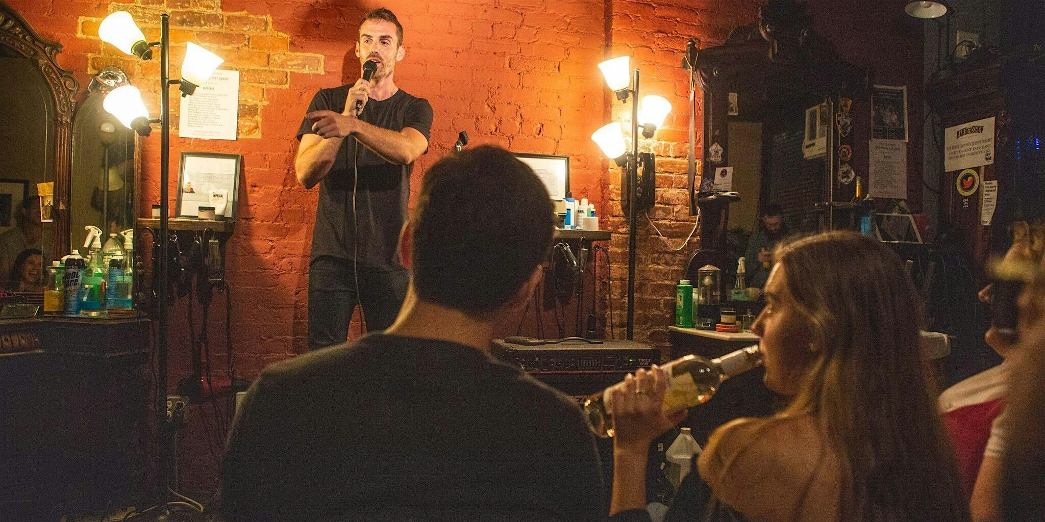 Live comedy show inside the barbershop — comedian performing for an intimate crowd in the East Village